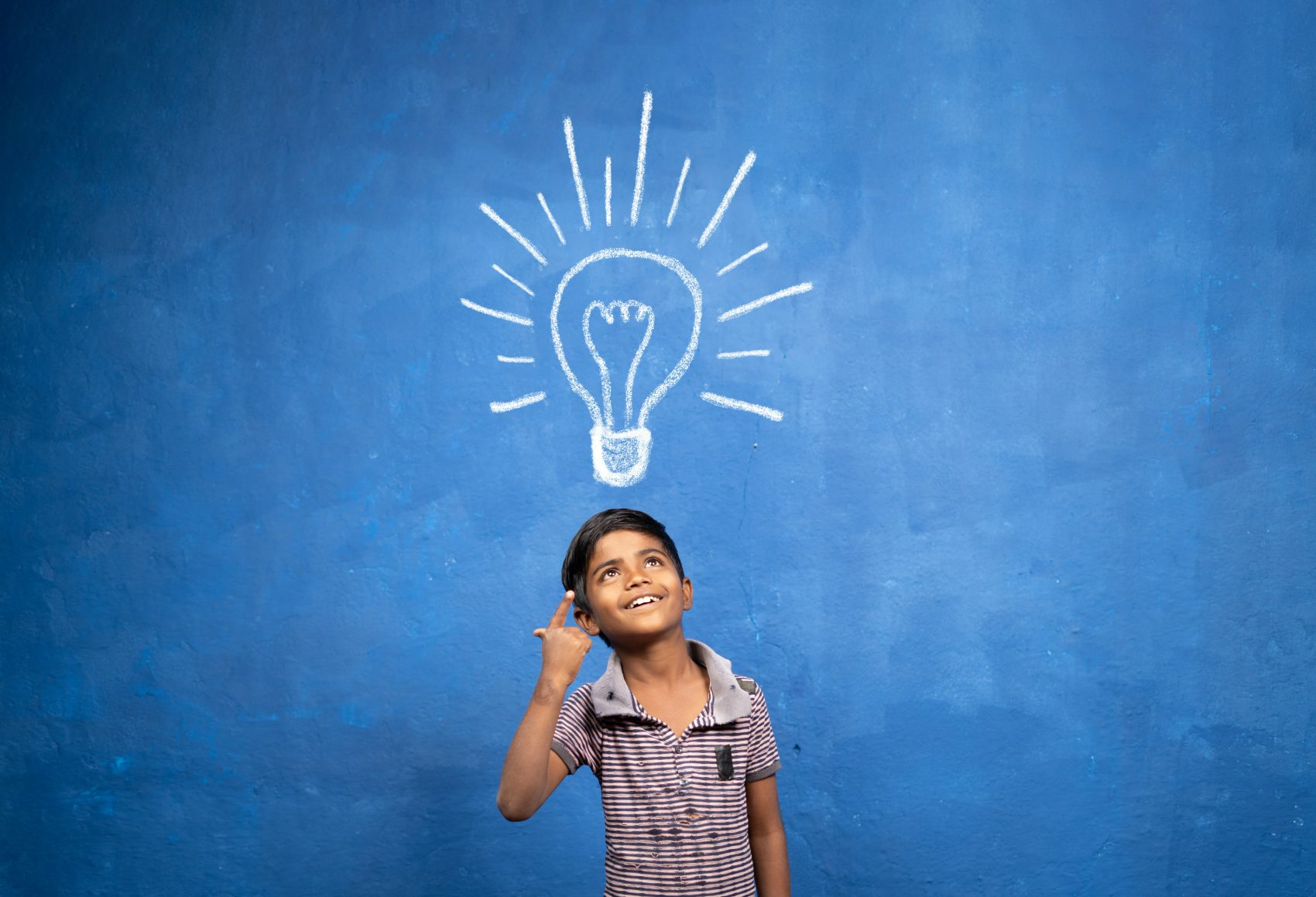 Child looking up at a drawn lightbulb, illustrating an insights article